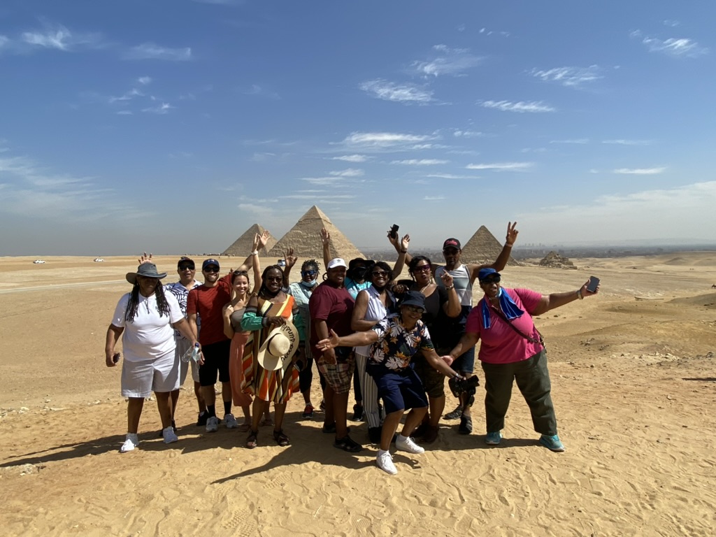Travelers celebrating together in front of the pyramids